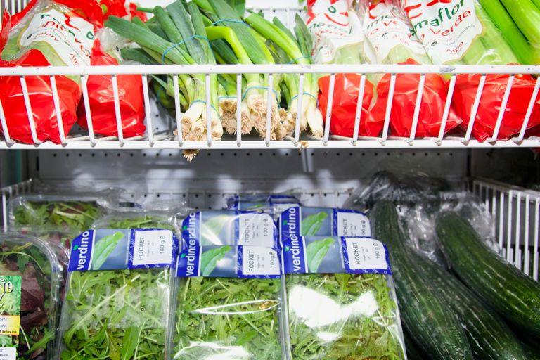 Verduras de hoja verde presentadas en la estantería del supermercado.